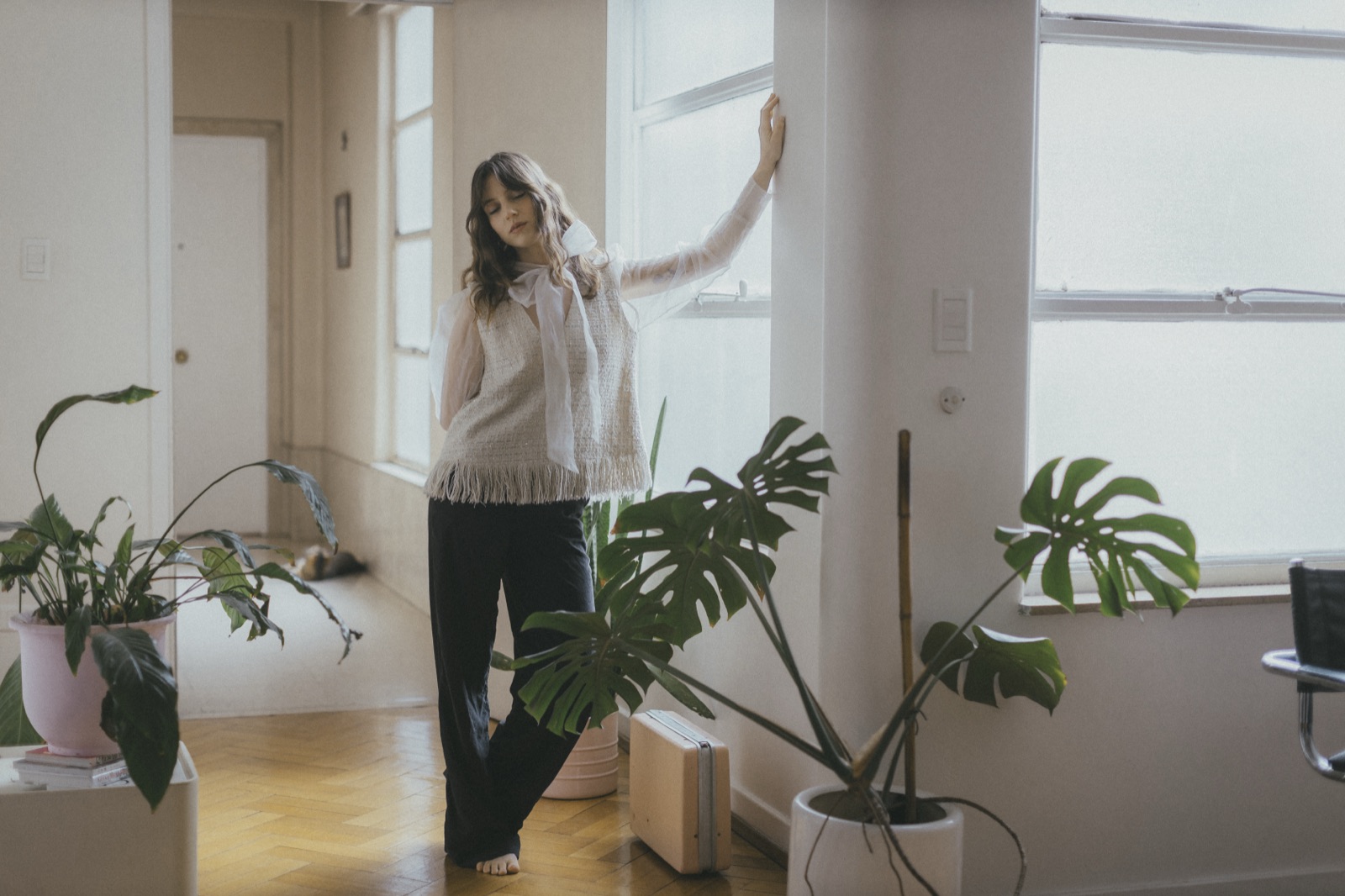 Agostina Faedda de pie junto a una ventana, entre plantas