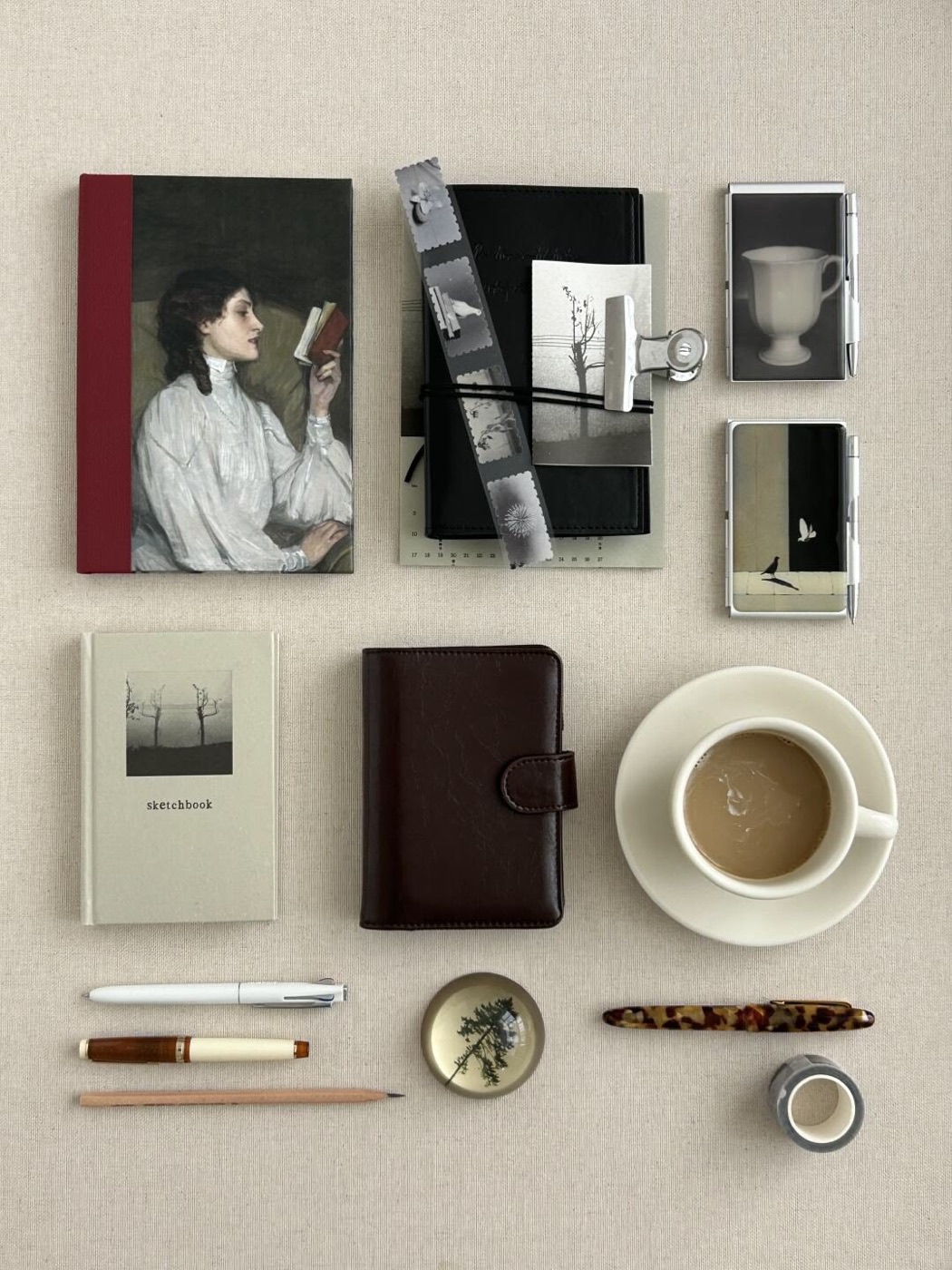 Libreta con pintura clásica, agenda de cuero, café y lapiceras