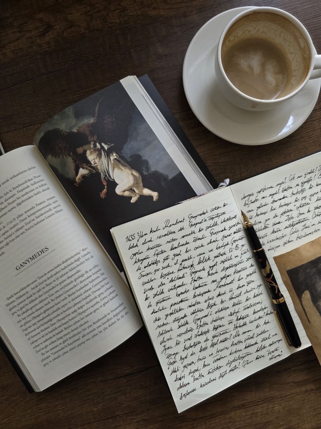 Libro abierto, cuaderno escrito a mano y café