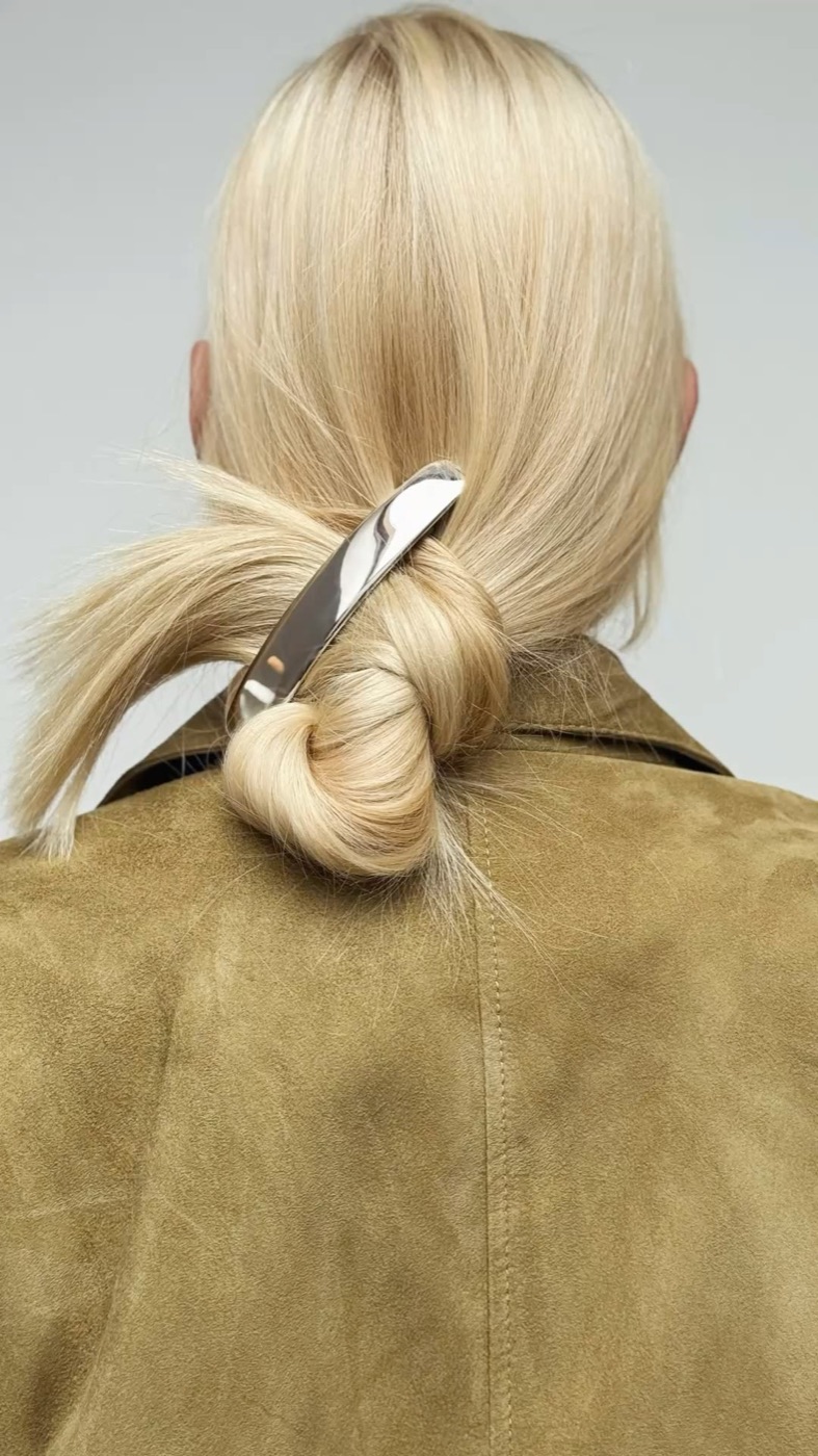 Pelo rubio recogido con una hebilla dorada, de espaldas